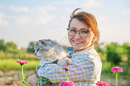 怀着猫的中年妇女户外肖像小猫猫科动物猫咪喜悦动物女孩女士灰猫雀斑女性图片