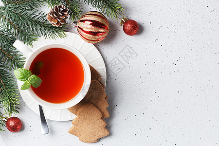 一杯茶和圣诞饼干放在桌边 新年装饰品的桌子上 复制空间图片