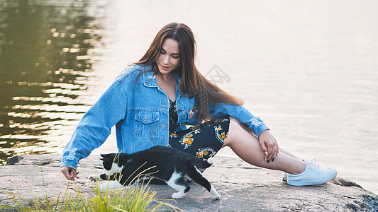一个女孩在湖边玩猫刷子乐趣闲暇婴儿朋友成人快乐宠物微笑女孩图片