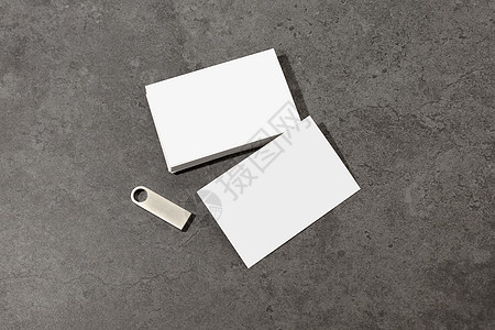 桌上空白的白色名片 带有空白的金属 U 盘 品牌标识的样机 可以显示卡片的两面 图形设计师的模板 自由空间 复制空间图片