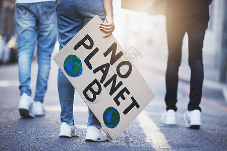 在柏油马路 街道或城市上张贴气候变化海报或横幅抗议的人 一群妇女的腿 为全球变暖 世界环境变化或拯救地球而步行或集会图片