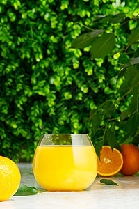 一杯新鲜橙汁 绿色背景上含新鲜果实的鲜橙汁早餐液体饮食热带玻璃叶子稻草食物水果乡村图片