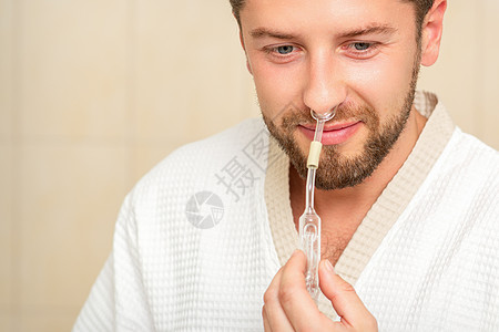 接受鼻腔吸入的年轻caucasians男子 在医院鼻子里流着基本油个性药品寂寞血剂鼻音治疗男人酊剂心血管病人图片