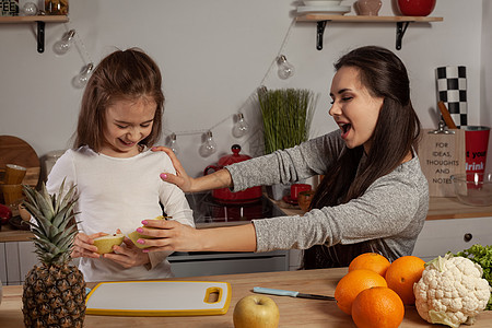 母亲和女儿正在做水果切菜 在厨房玩得开心些孩子们食谱父母菠萝成人菜花橙子食物烹饪黑发图片