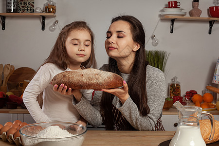 母亲和女儿正在烤面包 在厨房玩得开心 笑声乡村牛奶菜单女性成人父母女士食物烹饪黑发图片