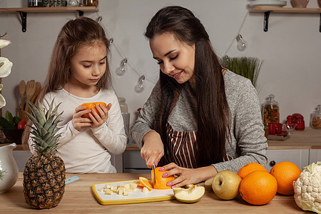 母亲和女儿正在做水果切菜 在厨房玩得开心些食谱菜花乐趣菠萝童年孩子菜单黑发成人乡村图片