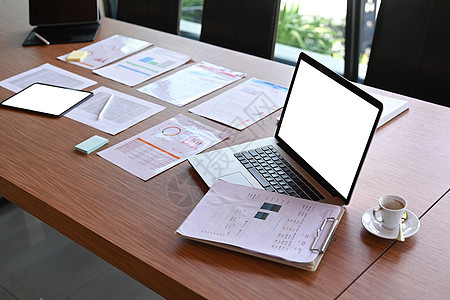 办公室木制桌上的笔记本电脑 咖啡杯和财务文件图片