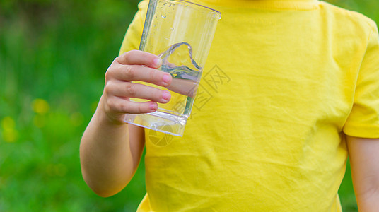 小男孩在公园里喝水和杯子婴儿情感孩子框架微笑女孩液体标签食物生活图片