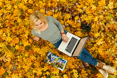 秋季公园拥有笔记本电脑和照片书的妇女浅色内饰学生杂志专辑写真集教科书白皮书女性照片图片