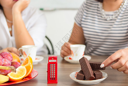 传统下午的英国仪式 下午茶茶 象征着像玩具电话箱这样的不纯度女士女性英语文化摊位盒子巧克力水果甜点电话亭图片