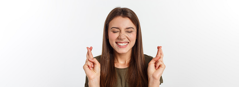 特写肖像希望美丽的女人交叉她的手指 睁开眼睛 希望 问最好孤立在灰色的墙壁背景上成人白色微笑快乐头发工作室女士女孩运气手势图片