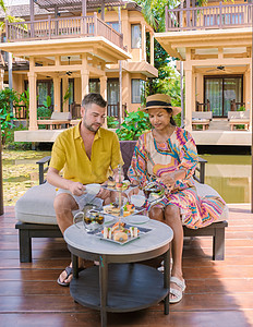 在水塘喝下午茶 在泰国热带花园喝下午茶男人长笛桌布花园酒店蛋糕架奶油时间庆典夫妻图片