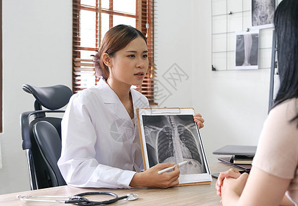医生在诊所向病人显示X光结果药品男人女性从业者诊断x光办公室胸部射线疾病图片