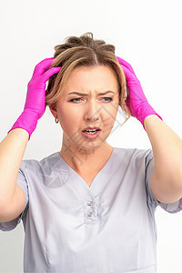 情绪震惊的年轻女医务工作者双手抱头 对白人背景 感染 流行病 病毒和疾病概念陷入恐慌头发衣服成人偏头痛压力挫折临床药品工作室诊所图片