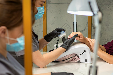 两个女人在美容院接受修指甲治疗程序员工服务客户仪器奢华工作桌子女士美容师图片