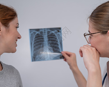 医生咨询一名天主教妇女 并对肺部X光片进行评论胸部疾病职业外套考试治疗女士放射科病人保健图片