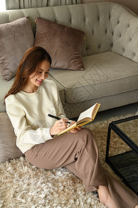 舒适的年轻女性在舒适的家中休息 写日记 业余活动 积极情绪观念专注小说家具教育休闲学习喜悦房间快乐文学图片