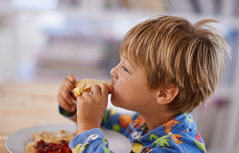 一个可爱的小男孩用花生酱和果酱 来吃烤面包 - 什么?图片