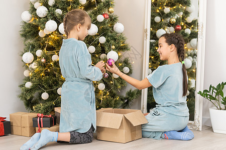 两个小姑娘在圣诞节睡衣彩灯面团蓝色家庭房间裙子童年女儿滚动图片