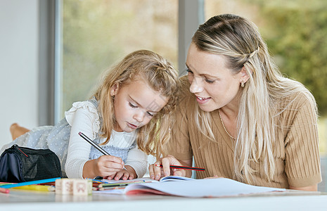 母亲在笔记本上写作时帮助年轻女孩完成学业 家庭作业或学前教育 妈妈在数学 历史或英语方面帮助 教学或辅导女儿 学生或正在学习的孩图片