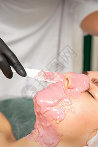 美容师在美容院对一位年轻女子的脸部 戴上悬浮面罩沙龙诊所女孩客户女士程序皮肤关心温泉身体图片