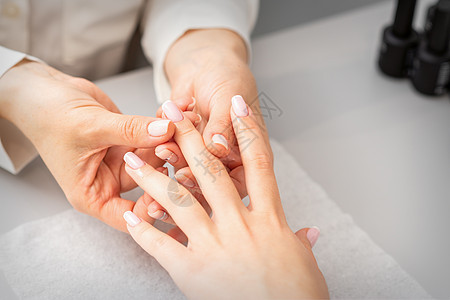 在美容疗养院修指甲 一只女人的手 用油在美甲沙龙按摩手指温泉化妆品客厅魅力反射奢华身体治疗客户成人图片