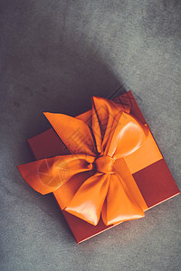 带有丝带和弓 圣诞节或情人节日装饰品的古老豪华假日橙色礼品盒展示购物奢华沙发装饰女士女性风格店铺销售图片