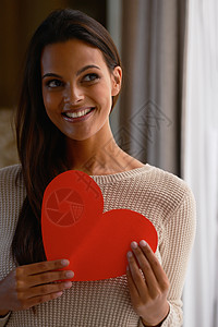 来自我的情人节的消息 一个美丽的女人拿着一张红色的心形卡片图片