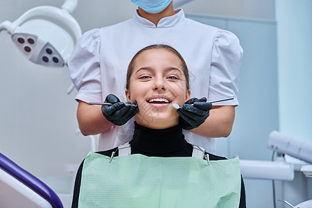 青少年女孩坐在牙椅上 手有工具的牙医手椅子矫正访问幸福卫生医生口腔科女士药品办公室图片
