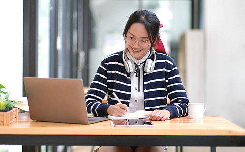 学生在室内笔记本电脑上学习  教育课程或培训 研讨会 在线教育概念 带现代笔记本电脑和耳机的亚洲女性在家学习大学应用工人居家计算图片