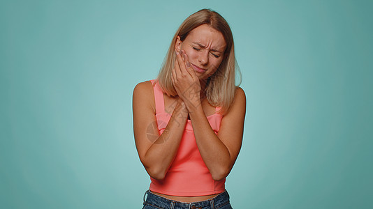 妇女触摸面颊时有牙痛 牙疼洞口腔或腹膜炎 等待牙医预约蓝色背景灵敏度伤害女性工作室胡须卫生牙科保健图片