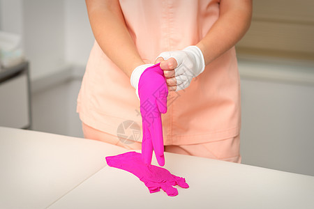 戴上橡皮粉色手套的美容手准备接待客户卫生沙龙职业治疗手指程序乳胶药品护士手臂图片