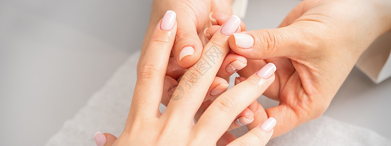 在美容疗养院修指甲 一只女人的手 用油在美甲沙龙按摩手指魅力课程工作室娱乐专家女士护理客厅程序擦洗图片