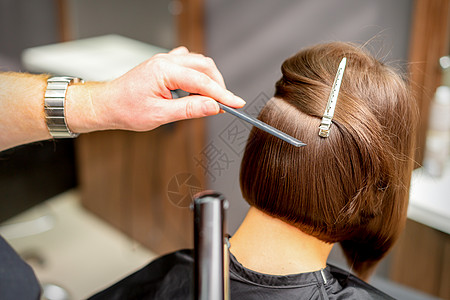 毛发画家正在清理黑发年轻女人的短发 在理发厅里用平板铁打近身 关上门治疗造型师工作室成人顾客梳子发型女孩女士头发图片