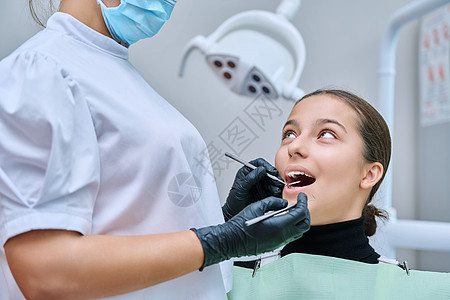 在诊所接受牙科检查的年轻少女妇女矫正口腔科医生办公室工具手套微笑访问女士牙疼图片