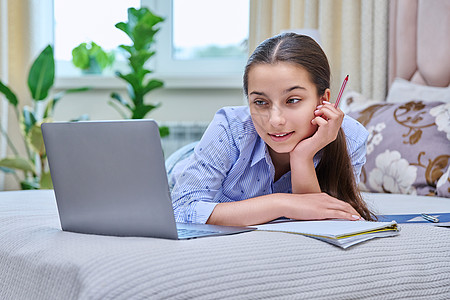 未成年女学生躺在膝上型电脑的床上 远程学习远程写作桌子大学谎言房子成人女士青少年女孩图片