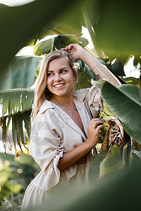 靠近香蕉丛绿叶的异国情调的热带女人 度假的热带岛屿女孩身体太阳头发奶油香蕉健康植物裙子树叶温泉图片