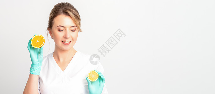 微笑的女性营养学家拿着切片橙子 看着摄影机反白背景 健康饮食概念 笑声排毒药品辅导损失免疫饮食手套实验室健康福利图片