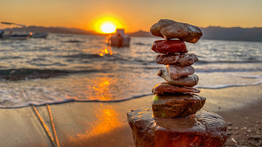 日落时沙滩的岩石平衡 近在眼前图片
