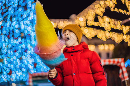 圣诞市场上拿着棉花糖的男孩 圣诞市场上快乐的孩子 圣诞节家庭的传统休闲男人幼儿园摊位童年雪花棉布棉花喜悦糖果假期图片