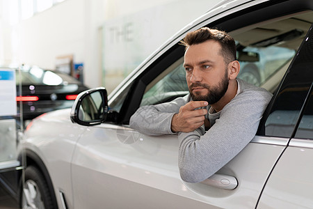 一名男子在汽车经销商购买一辆新车时 曾考虑过为家庭司机投保保险单图片