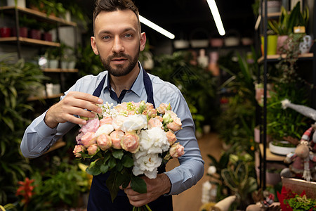 迷人的男花店家 手里拿着一束花束 庆祝国际妇女节图片