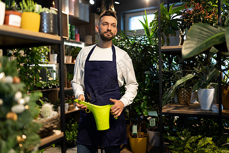 花店手持本底陶瓷植物的棚子园中心工人背景