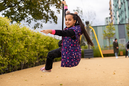 小女孩冲着小矮姑娘撞到子上天空太阳女孩森林公园跳绳速度快乐小姑娘绳索图片