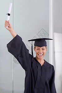 世界现在是她的牡蛎了 一位穿着毕业礼服的年轻女子 持有毕业证书长袍文凭学者繁荣成功微笑成人证书学生大学图片