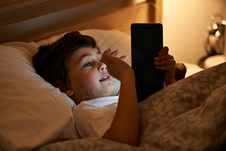 一些在床前看书的小男孩躺在床上 坐在平板电脑上玩耍孩子们阅读男性说谎互联网黑发童年卧室房子微笑图片