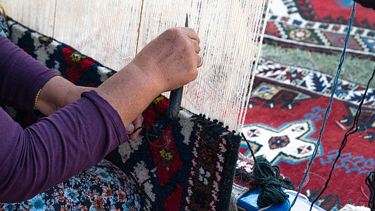 奶奶织地毯在一串线上 做地毯图片