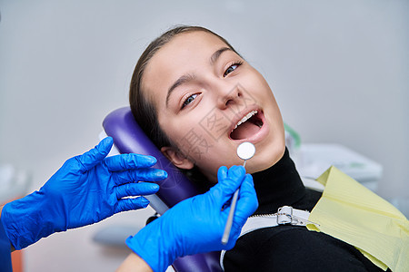 在诊所接受牙科检查的年轻少女女青年卫生治疗牙齿手套微笑女孩女性工具矫正牙疼图片