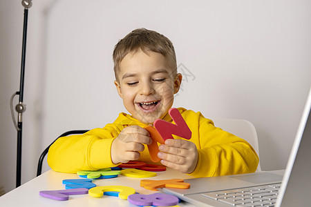 可爱 可爱的小男孩在线学习字母表 家里有笔记本电脑 孩子使用电子学习平台与老师进行视频通话并学习 儿童在家上学和远程教育小学生童图片