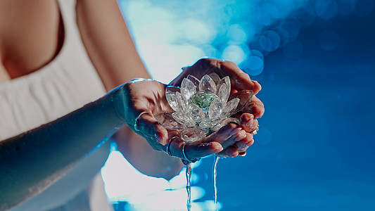 拿着易碎的莲花的妇女 清澈的水珠从水晶中滴落 宗教 昆达里尼 冥想 脉轮 精神内心世界的概念玻璃矿物反射手工女士手指女性抛光游泳图片